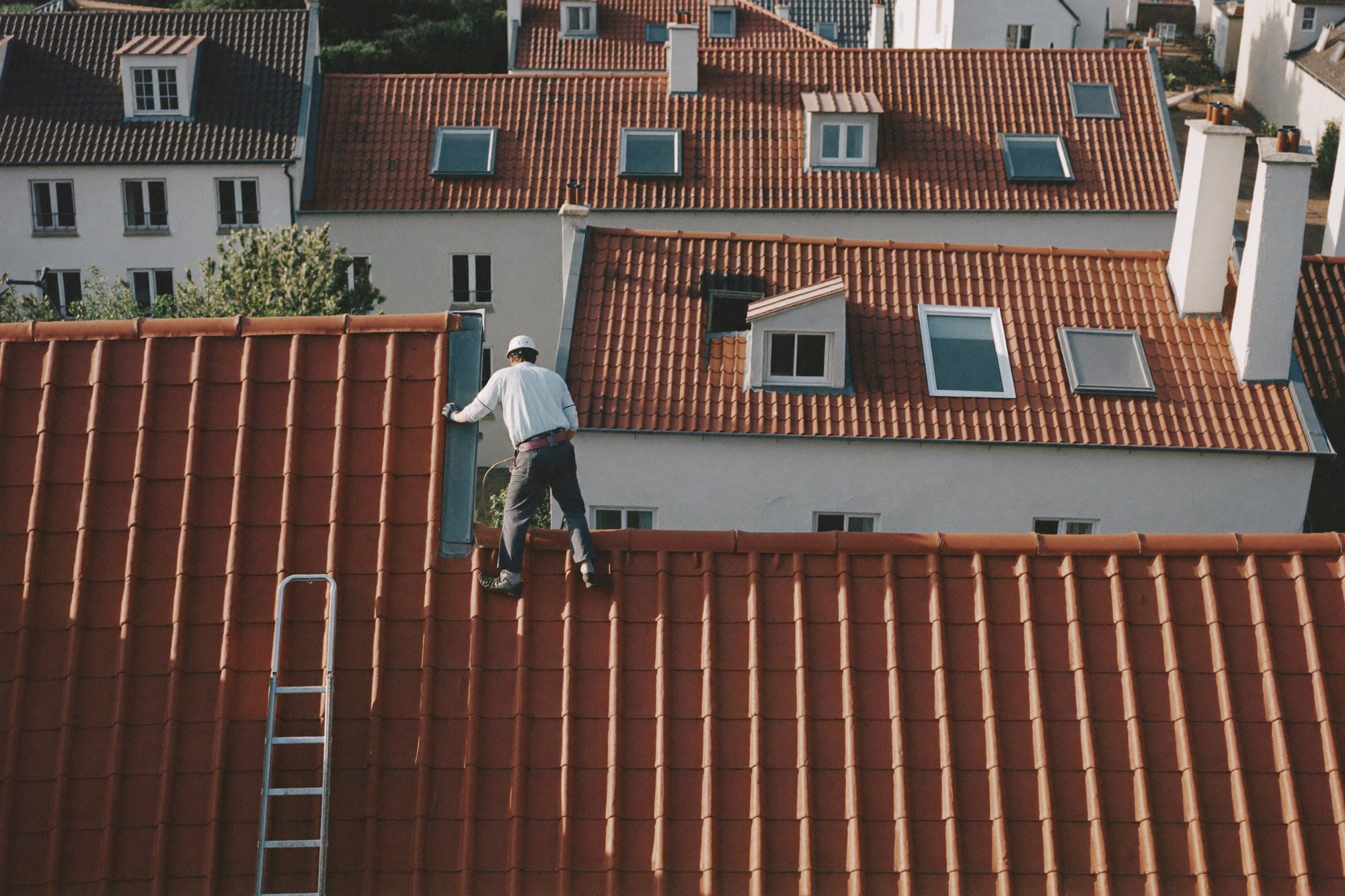Dachdecker prüft Dachziegel
